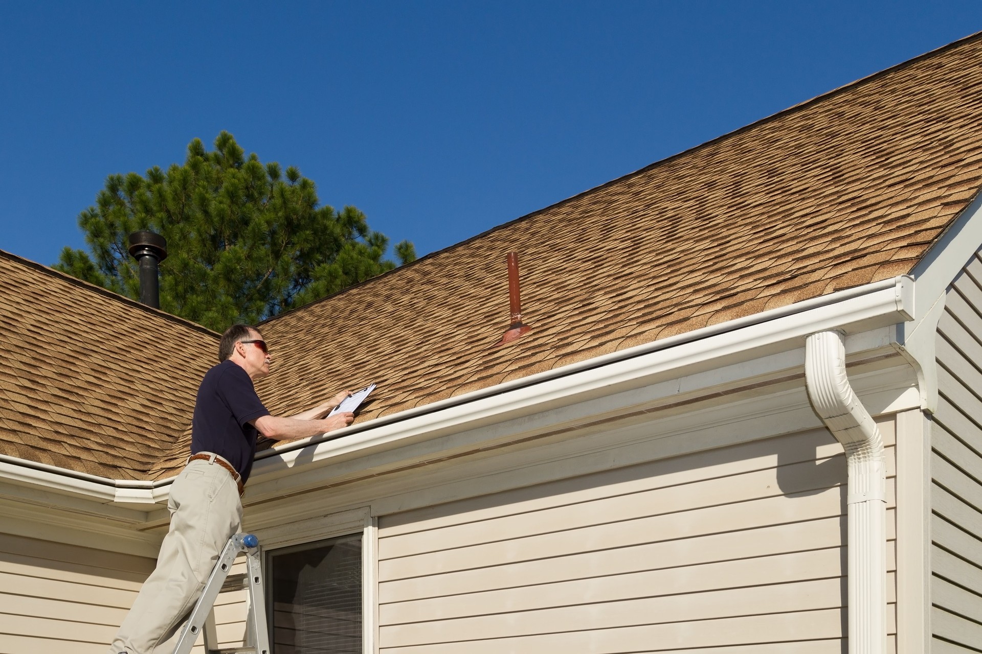 Home inspector examines a residential roof vent pipe.